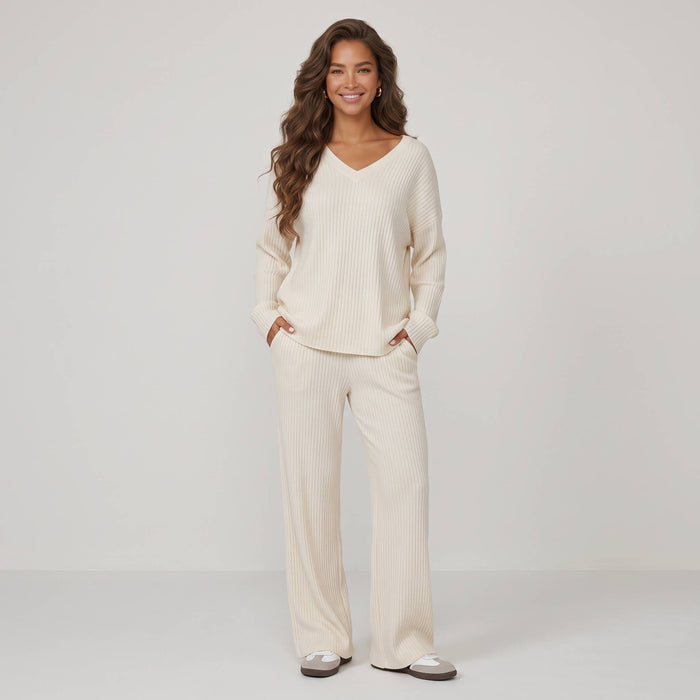 Woman wearing cream 2-piece ribbed knit loungewear set with V-neck long-sleeve top and straight-leg trousers