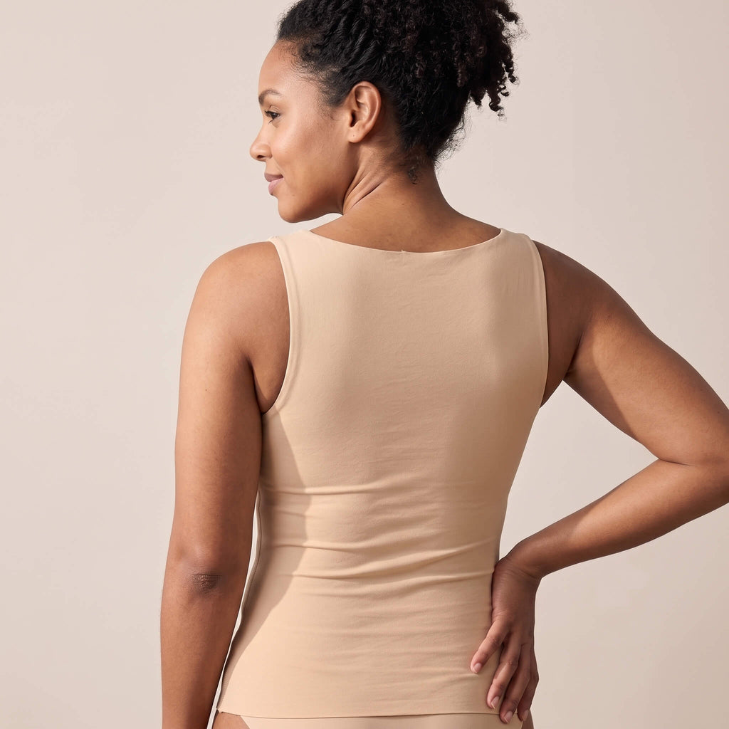 Back view of The Ease Comfort seamless bra tank top in nude beige highlighting wide smoothing back coverage